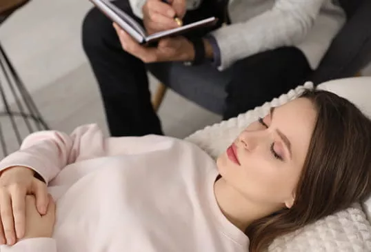 Psychologist in Richmond taking notes while client rests on clinic couch
